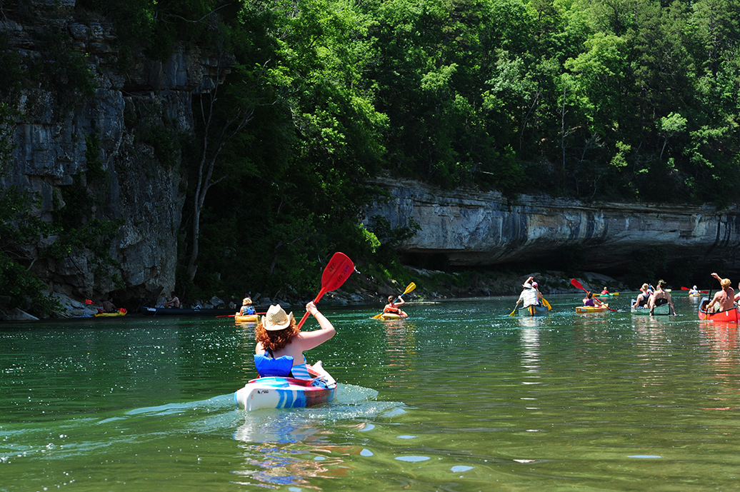 over 10 people in canoes in the river